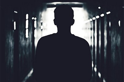 silhouette seen from behind in dark hallway