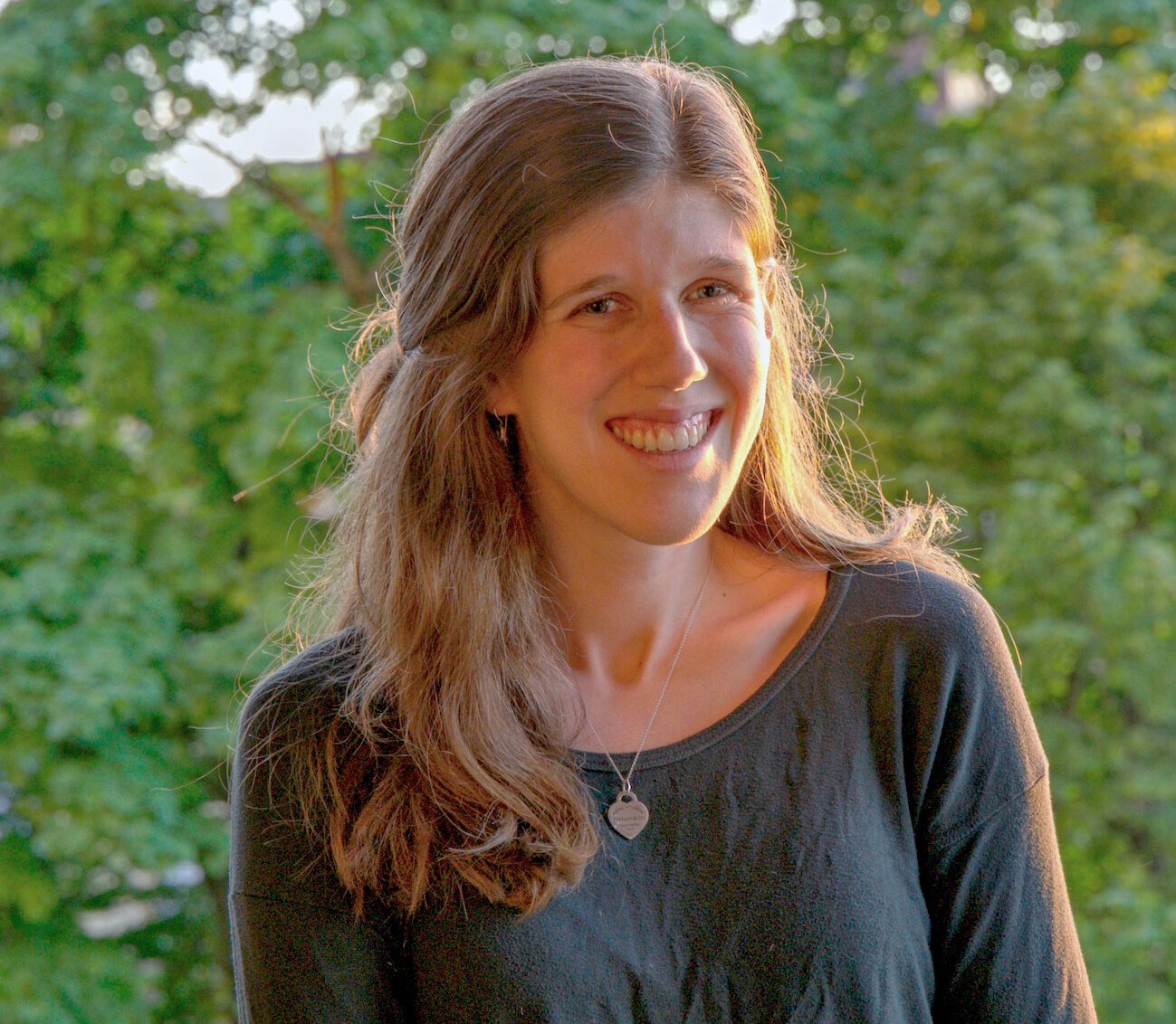 Portrait taken outside with trees in the background.