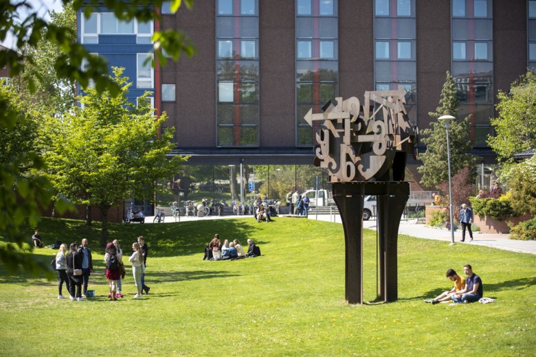 Student and staff at the lawn on campus Solna.