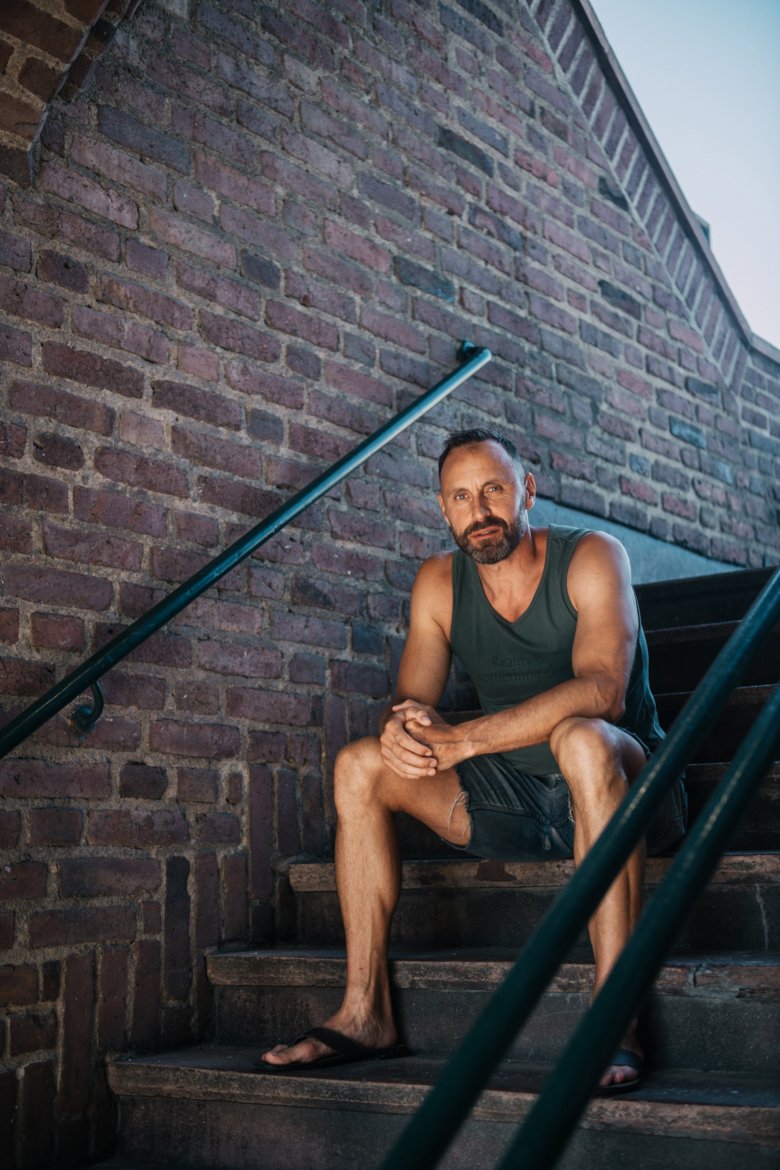 porträttbild av Mattias Sunnerborn som sitter på en trappa utomhus.
