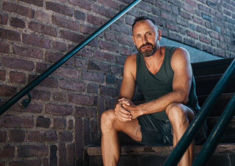 porträttbild av Mattias Sunnerborn som sitter på en trappa utomhus.