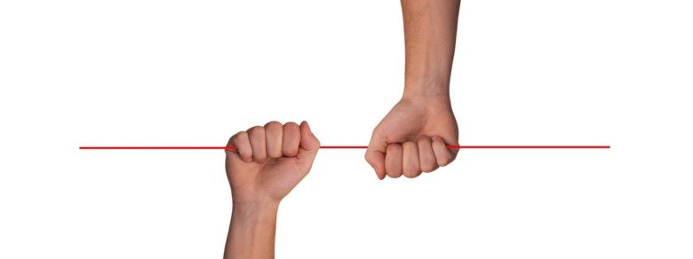 Hands holding a red stick.