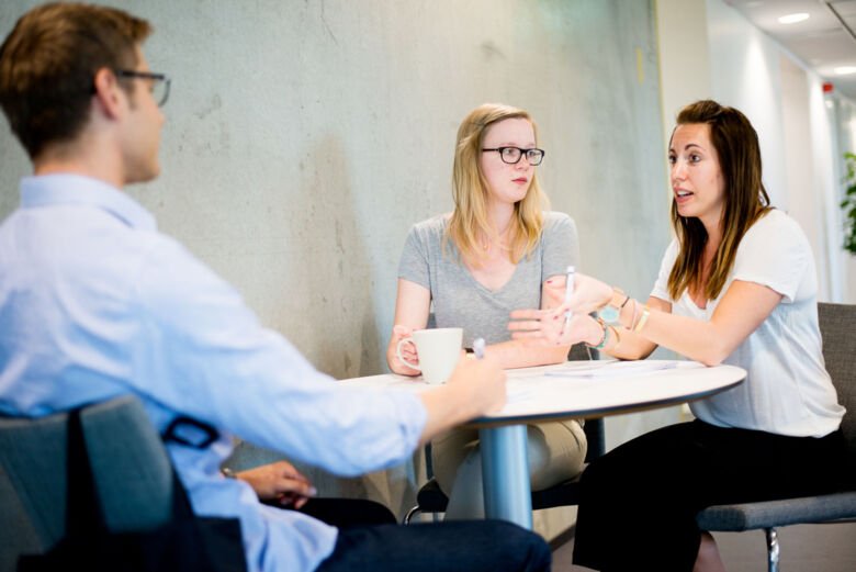 Two students talking with teacher.