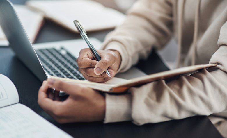 Person writing on notebook