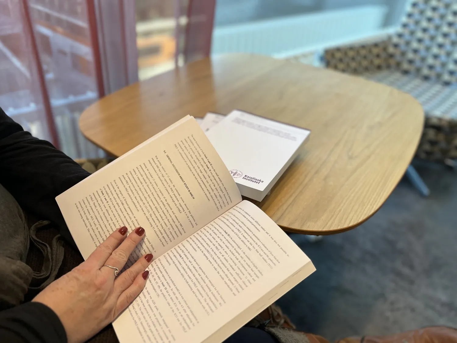 Kvinna läser i en bok, en avhandling.