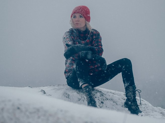 Picture of Bea Uusma outside in the snow, sitting on a mountain.