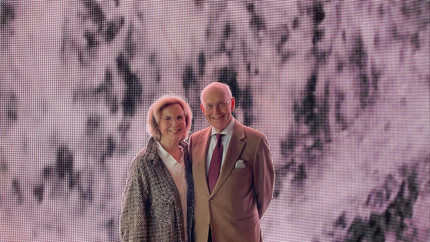 Porträtt på två personer framför grå vägg.