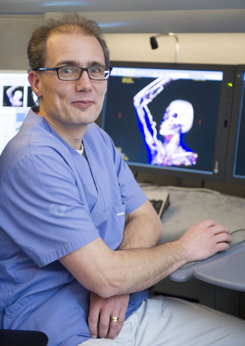 Torkel Brismar i labbet, i bakgrunden en skärm med en bild av ett kranium.