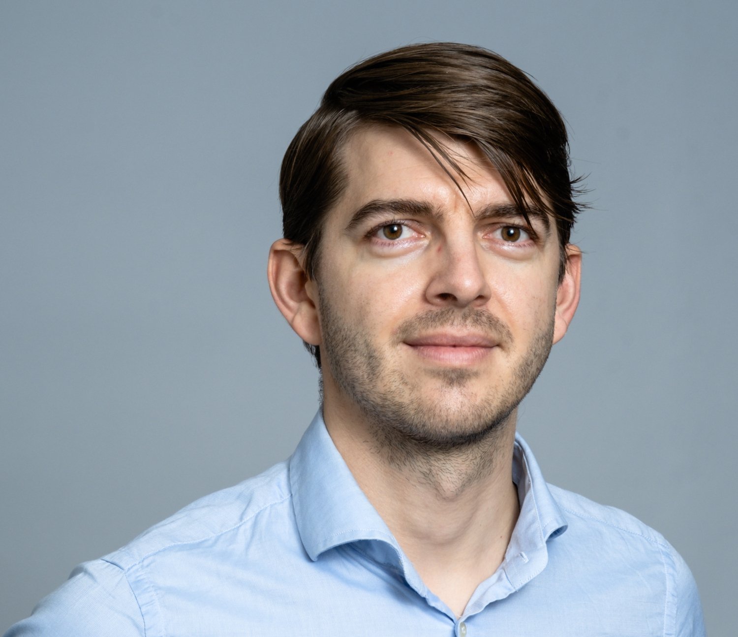 Portrait of Michael Ratz in blue shirt.