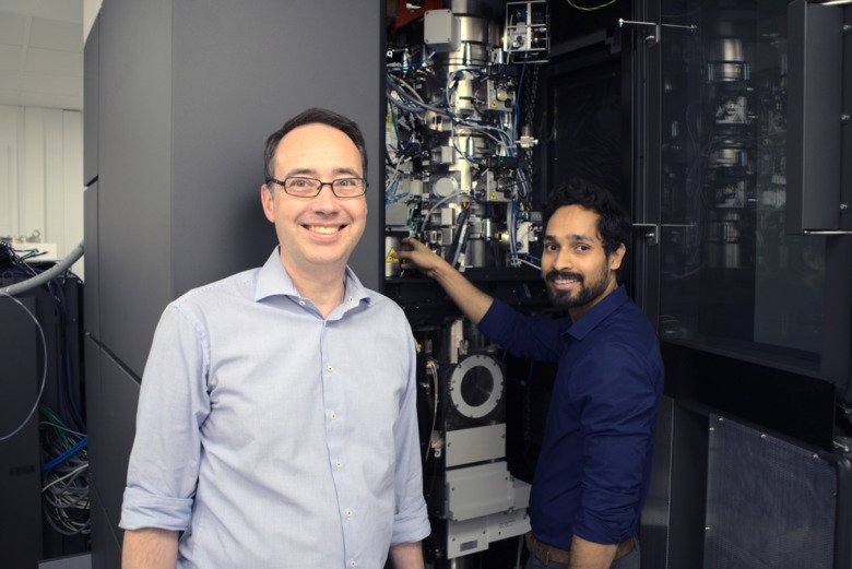 The researchers are standing in front of 3D-EM.