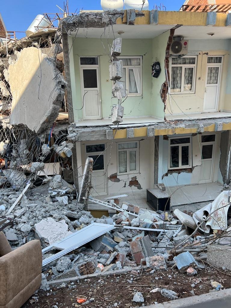 Houses that have been destroyed in an earthquake. Rubble in the street