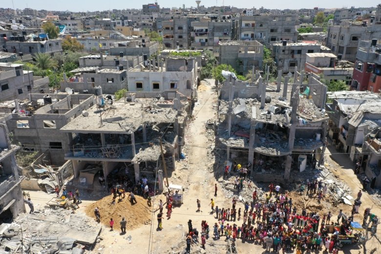 bombed out houses with their fronts destroyed and a group of people outside