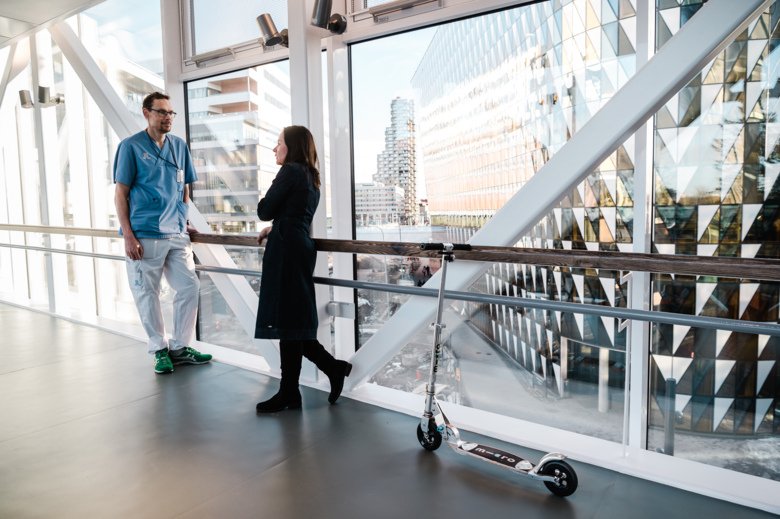 Picture of two people talking in a corridor.