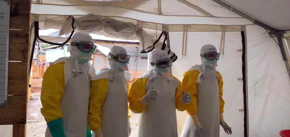 Fyra personer i skyddutrustning och ansiktsmask under ett ebolautbrott