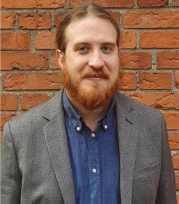 Porträtt av Erland Axelsson, anknuten forskare vid avdelningen för allmänmedicin och primärvård, NVS, framför röd tegelvägg..