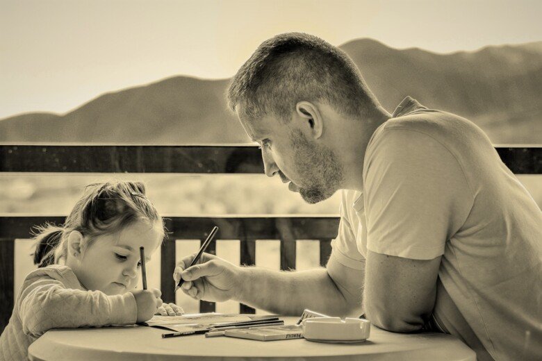 Bild på en pappa som ritar med sin dotter.
