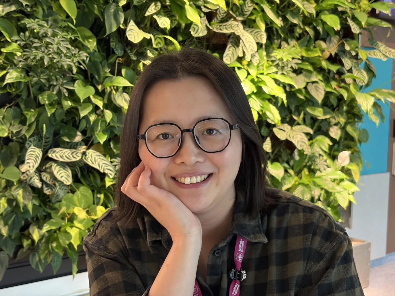 Portrait of a smiling woman, wearing glasses.