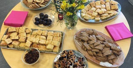 Table with plates of cakes and fruit