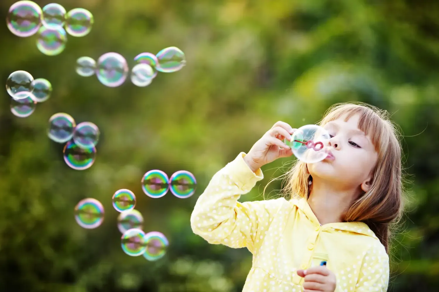 Young girl blowing bubbles.