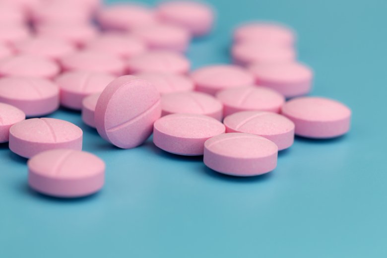 Pink pills on blue background