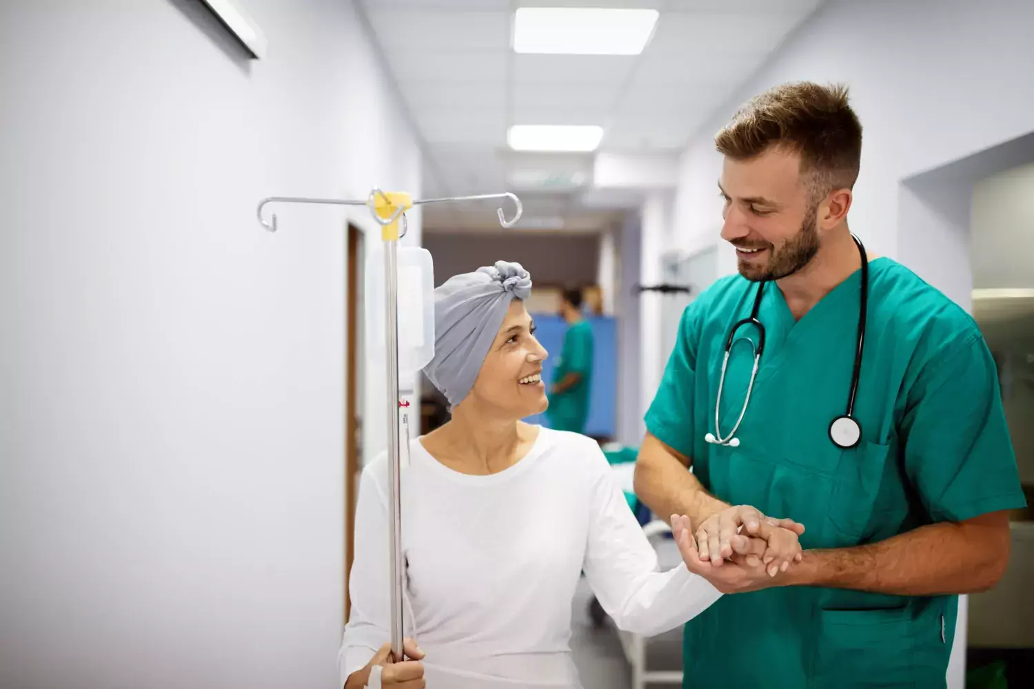 Cancer patient holding doctor's hand.