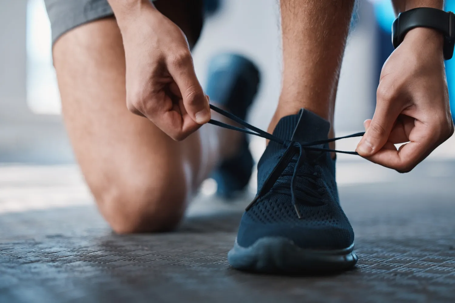 A very closed zoomed in picture of someone who ties a sporting shoe.