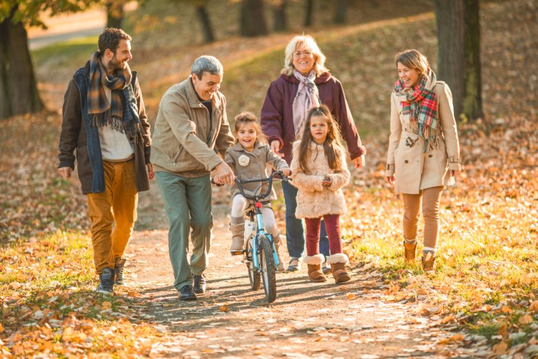 Familj i tre generationer som promenerar.