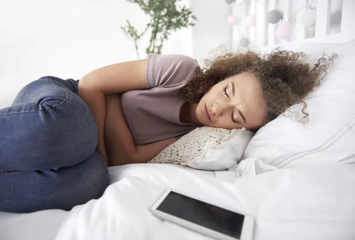 tonårsflicka som har ont i magen