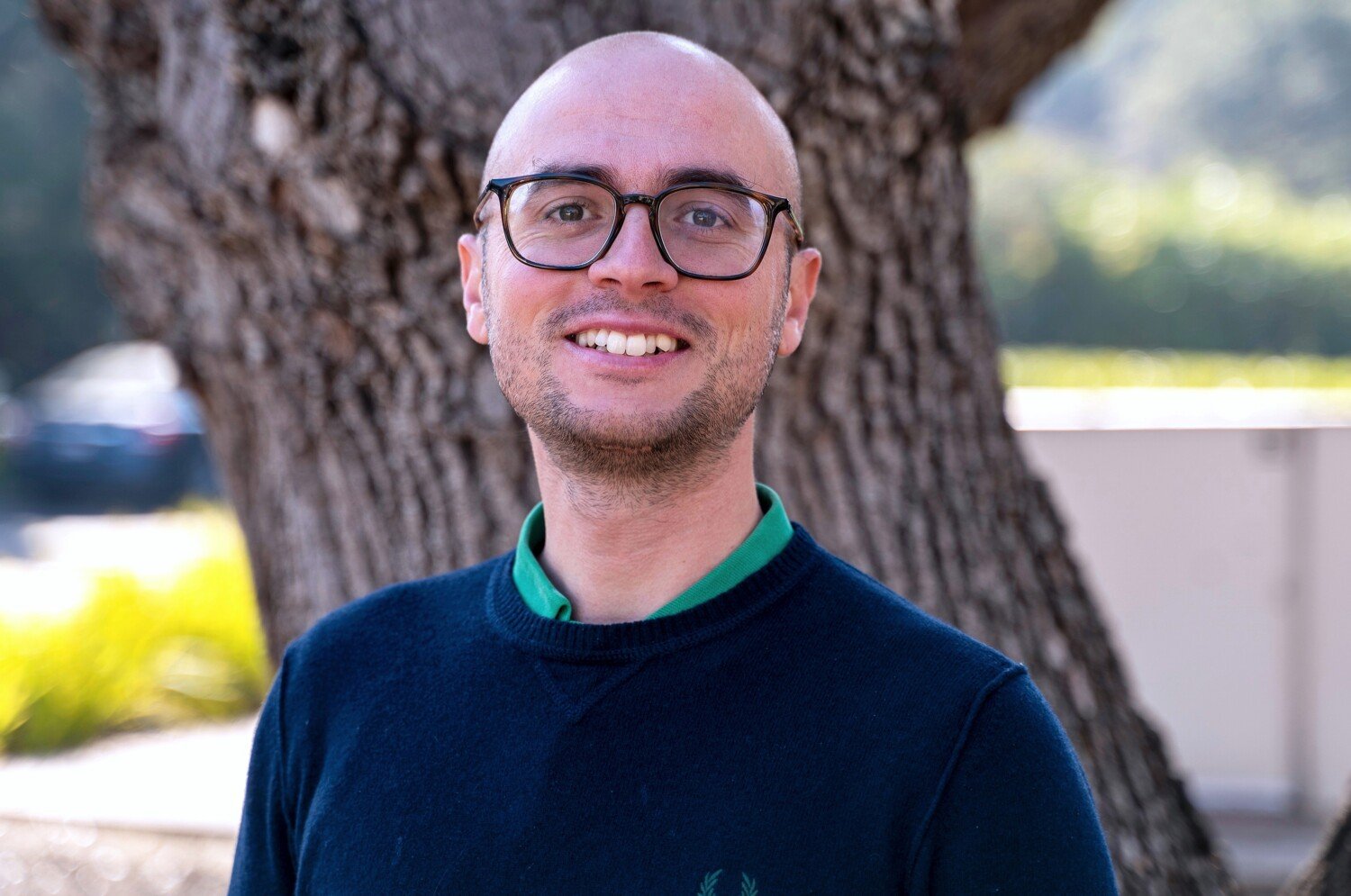 Portrait in front of a tree trunk.