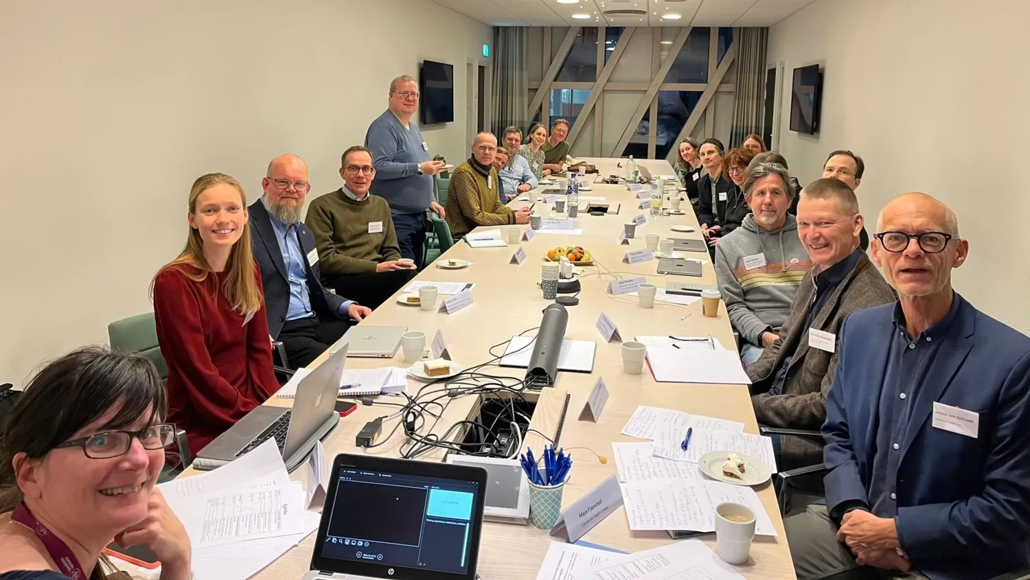 Several people sitting around a conference table looking at the camera