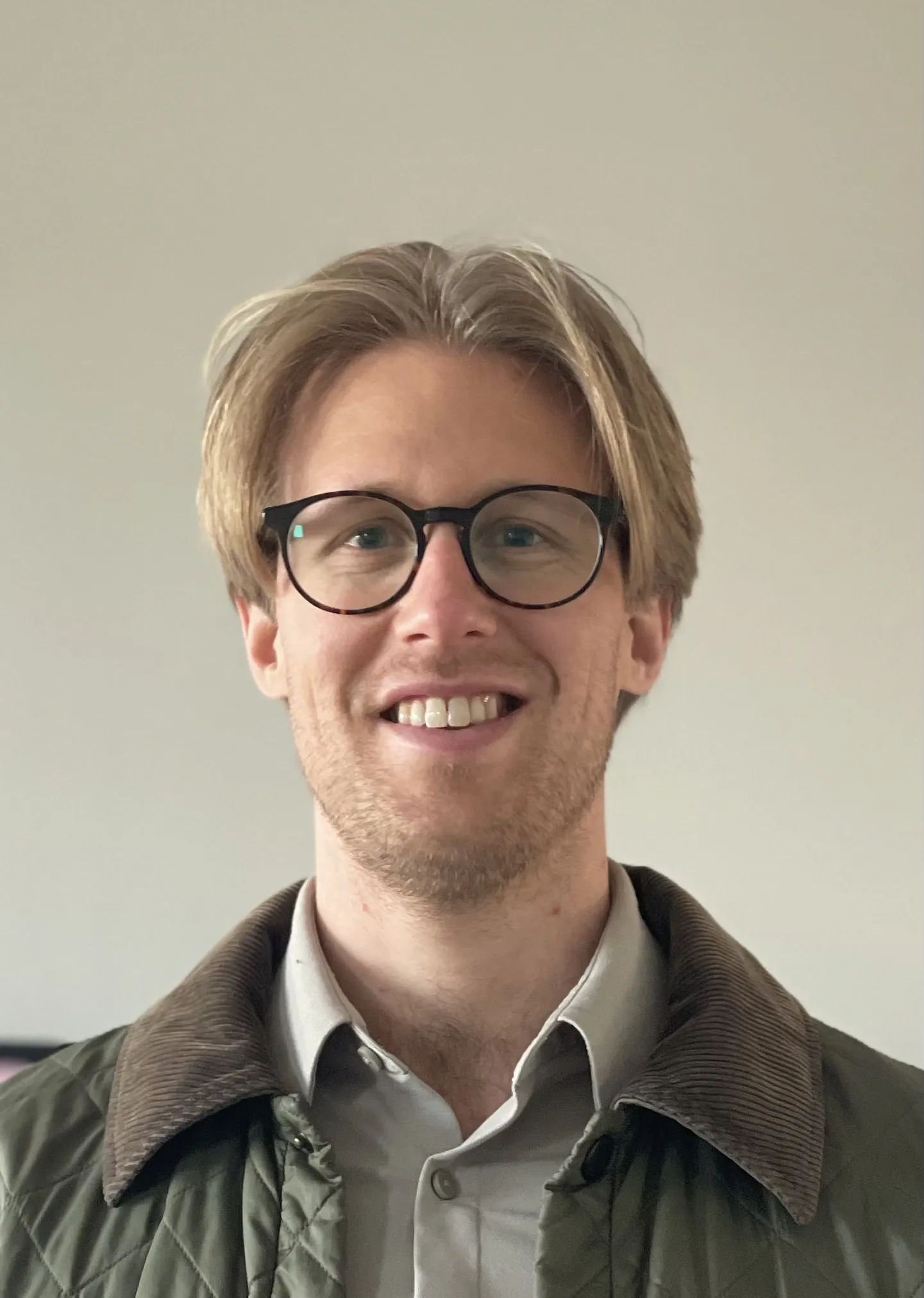 Portrait of a blonde man wearing glasses.