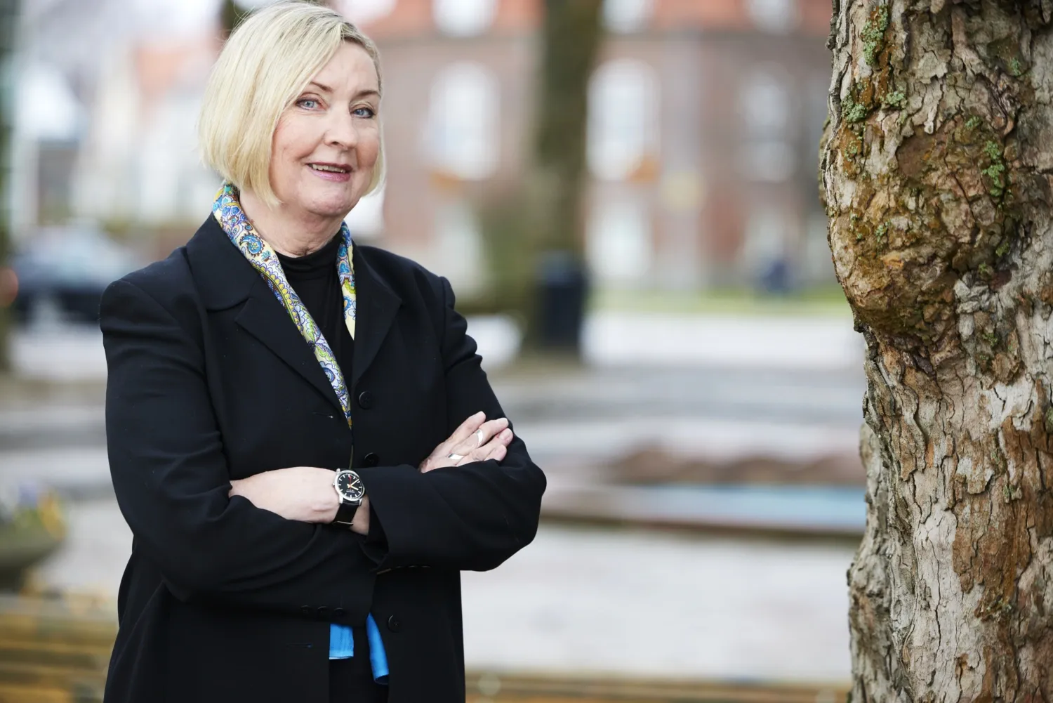 Porträtt av Christina H Opava, professor emerita, avdelningen för fysioterapi, NVS, stående utomhus vid ett träd..