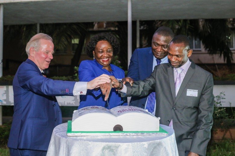 KI Presdent and representatives of Makerere University outside cutting a cake together