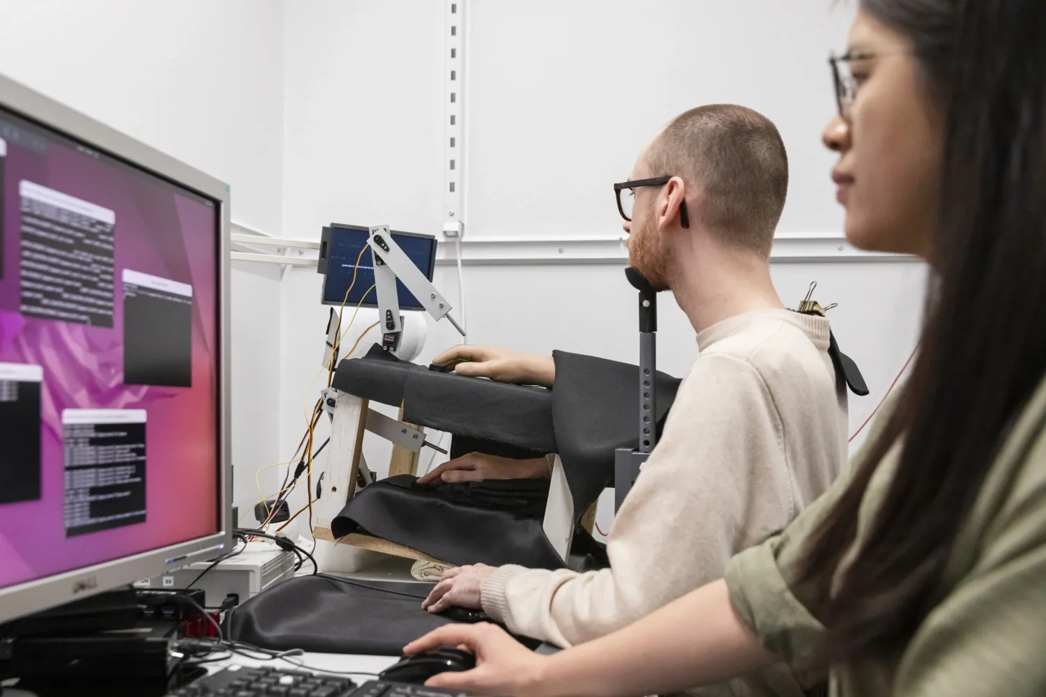 Two members of the lab expermimenting in front of a computer screen.