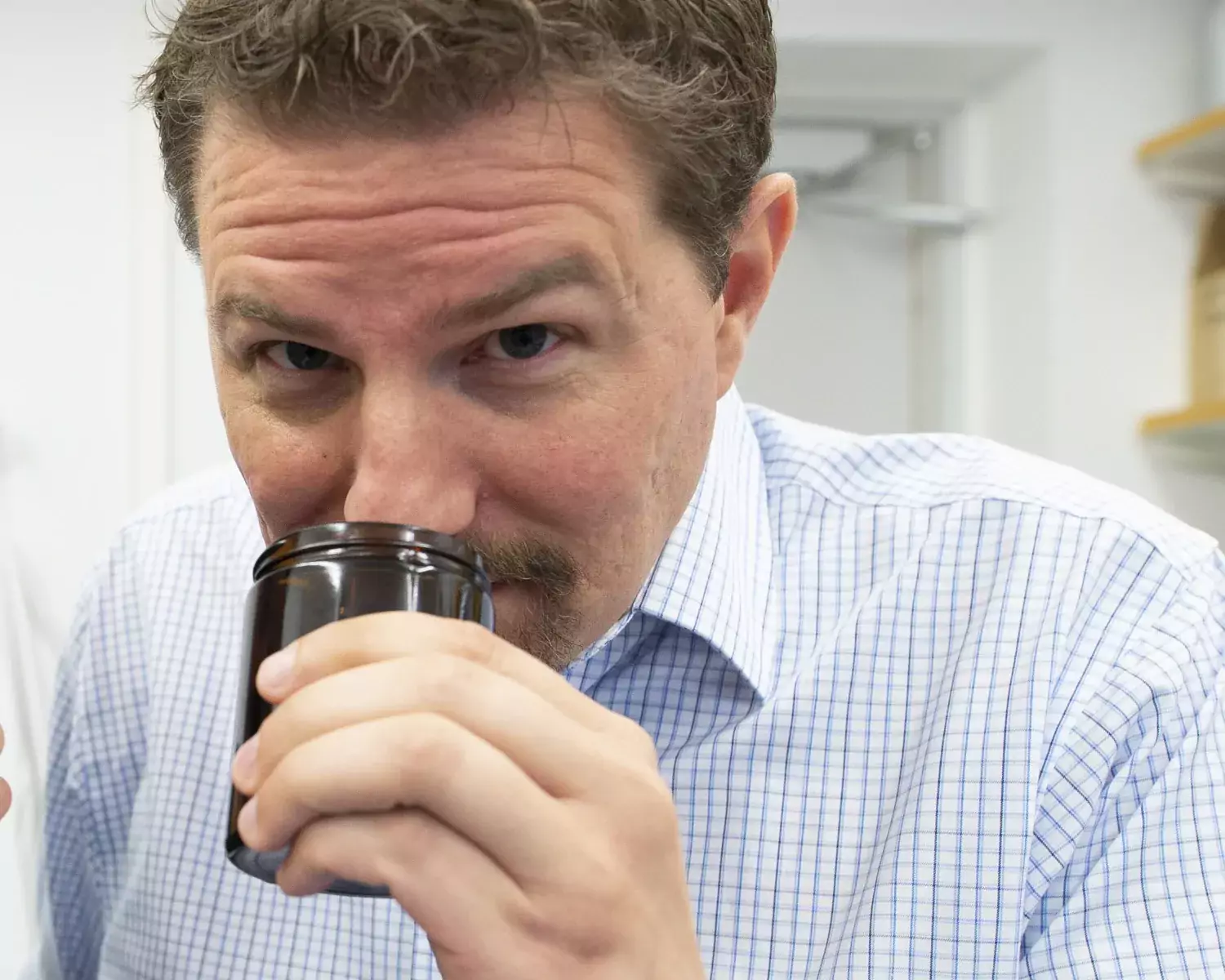 Johan Lundström smelling on something in a jar.