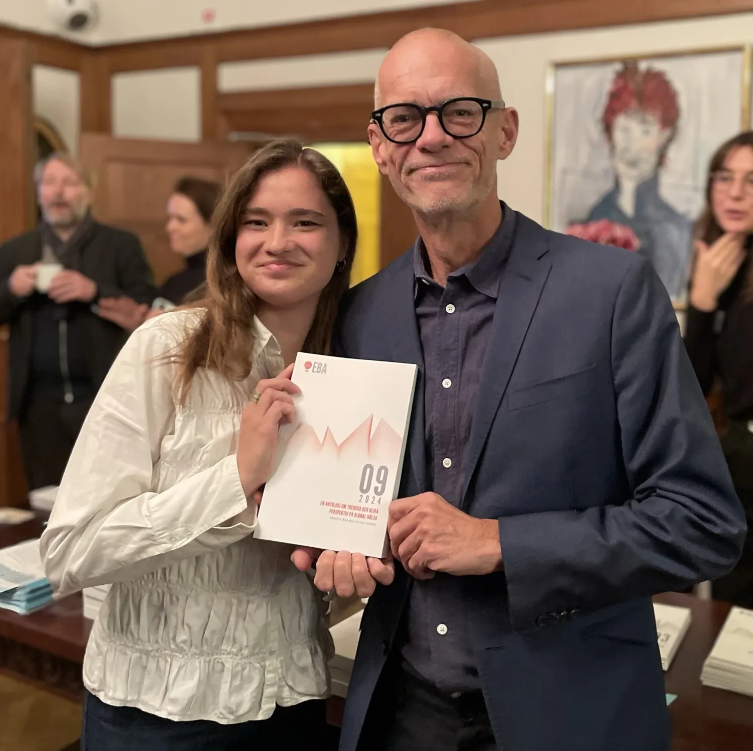 A woman and a man holding a book