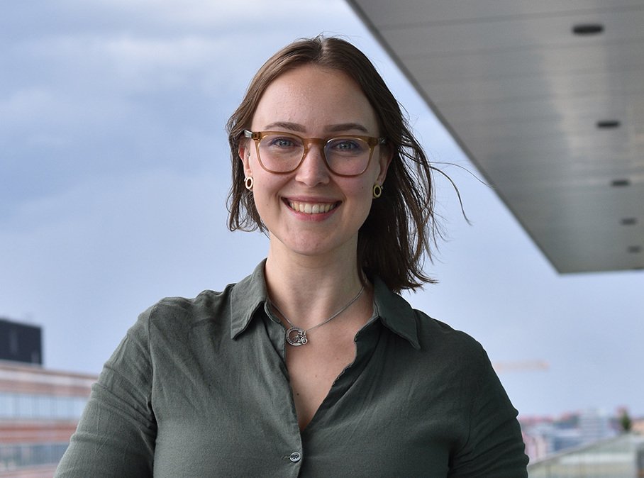 Porträtt av Vilma Alanko, doktorand vid avdelningen för klinisk geriatrik, NVS, ståendes utomhus på en terrass högt upp i Bioclinicum.