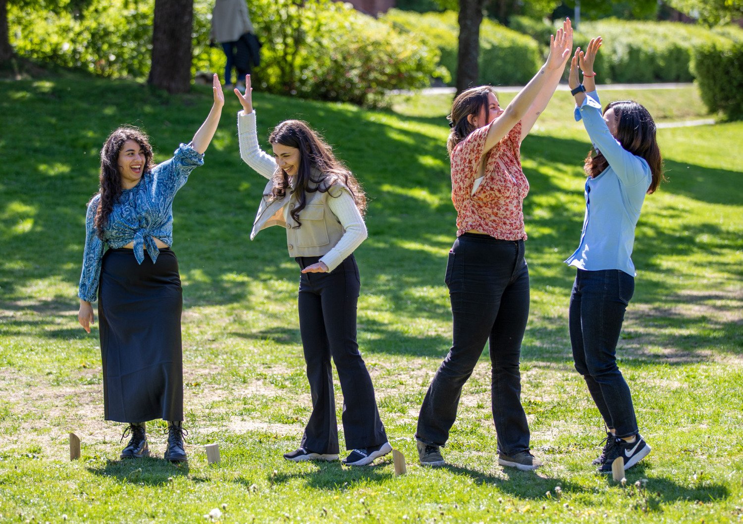 Studenter spelar kubb på gräsmattan utanför universitetsbiblioteket på campus Solna.