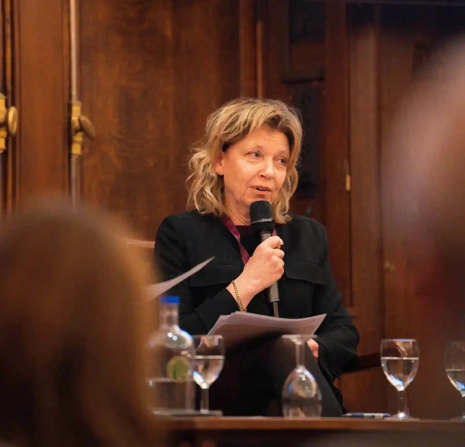 Bild på en kvinna med kort blond hår på en scen med en mikrofon