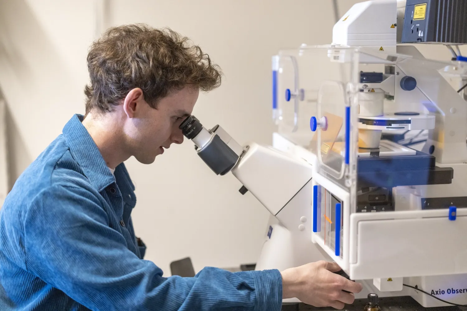 Man looking in to a microscope.