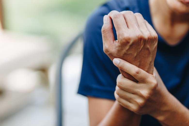 Picture of a hand holding a wrist in pain.