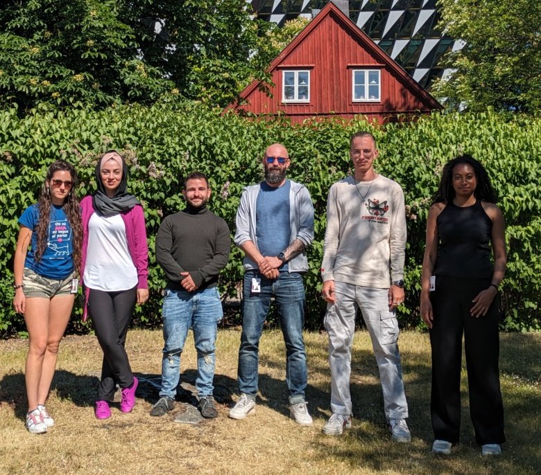 Group picture of lab members outside in front of the Aula, KI Campus Solna.