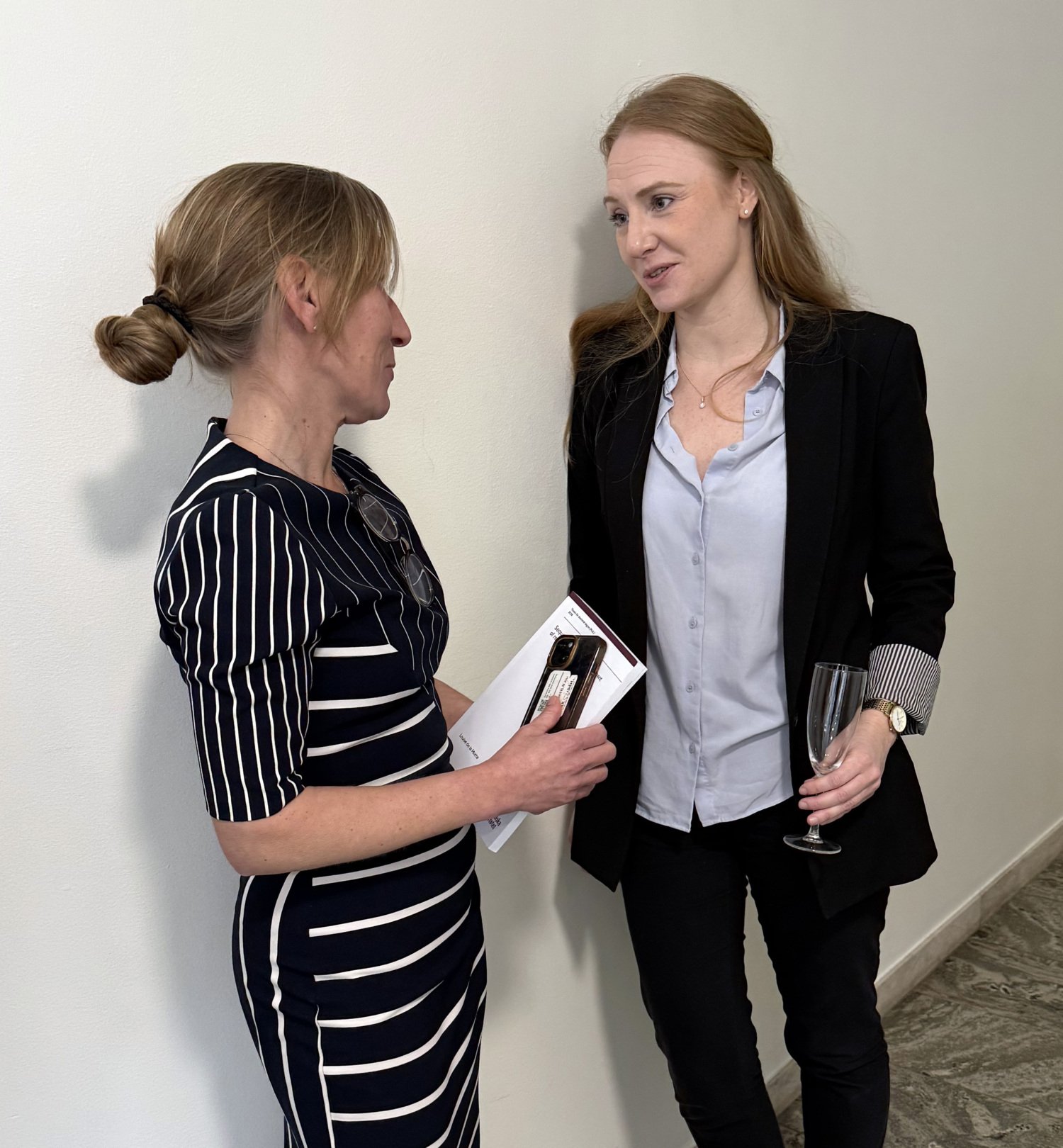 Två personer som står och samtalar med varandra