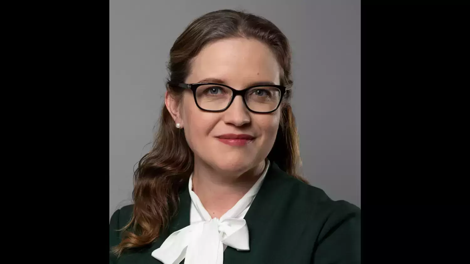Profilfoto på Maja Fjaestad. En kvinna i vit knutblus och glasögon