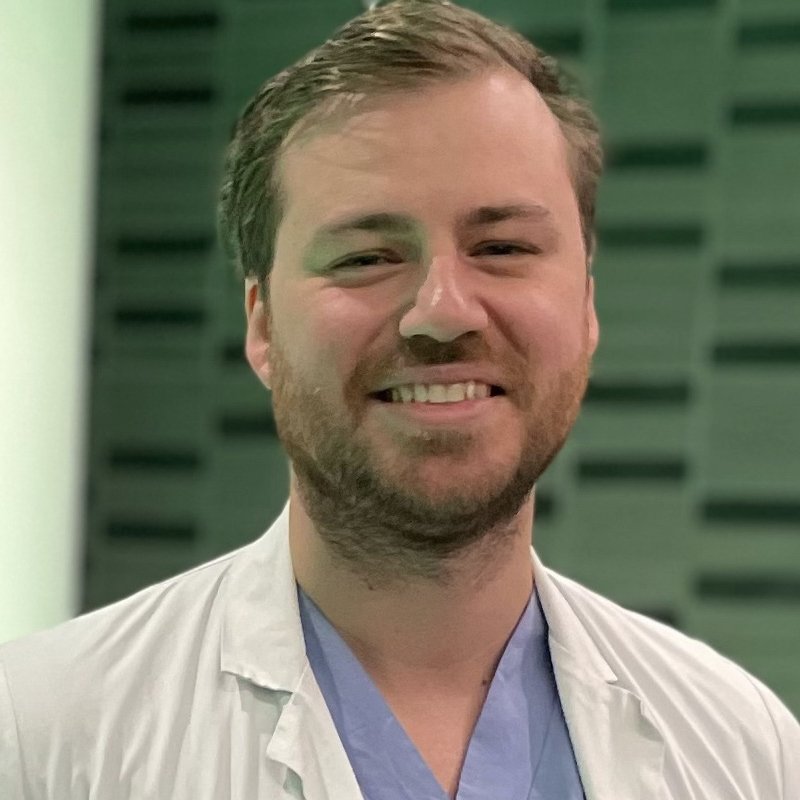 Portrait of Marcus Skribek in blue and white scrubs.