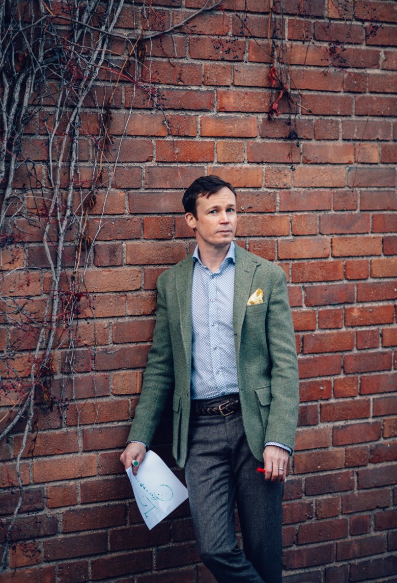 Martin Eklund in front of a brick wall.