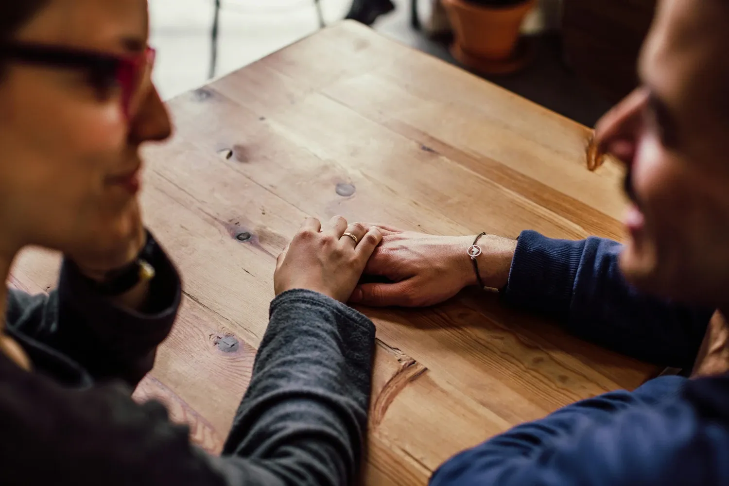 Two people talking and holding hands at a table