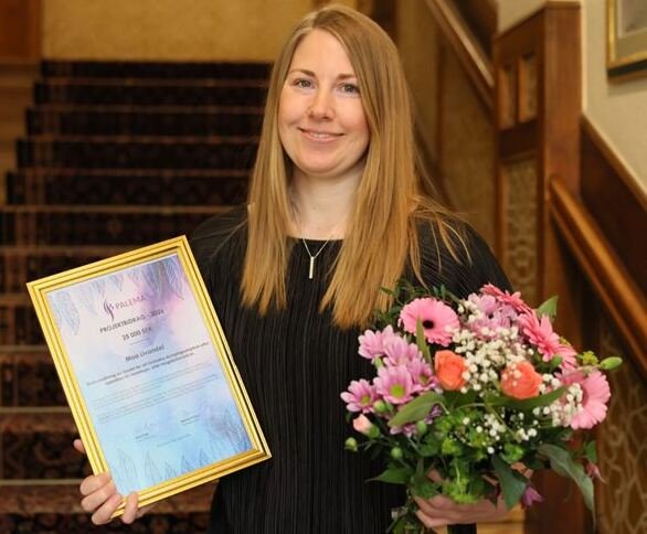 Portrait of PhD Student with Diploma and flower boquet