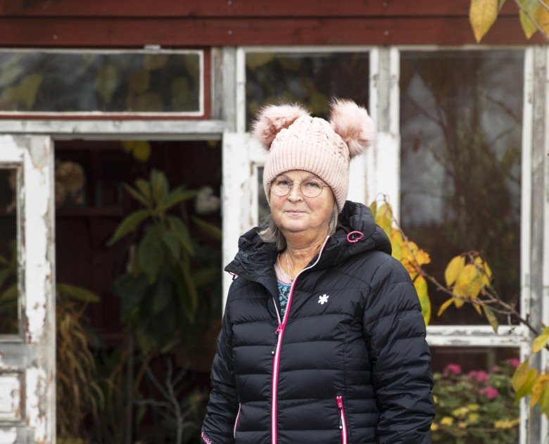 Monica Holmner standing outside in front of her house, there is leafs on the ground.