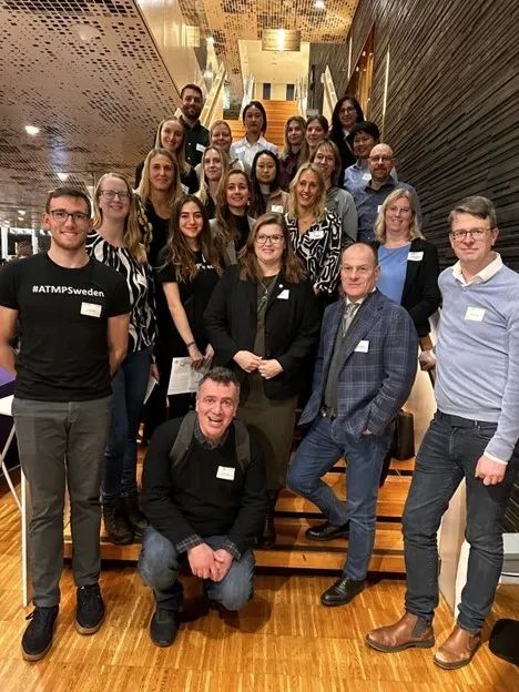 Group photo of about twenty people posing on a staircase.